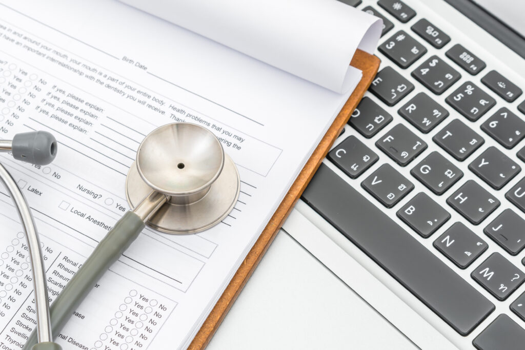 stethoscope and prescription on laptop