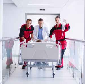 doctors pushing emergency stretcher bed in corridor at hospital